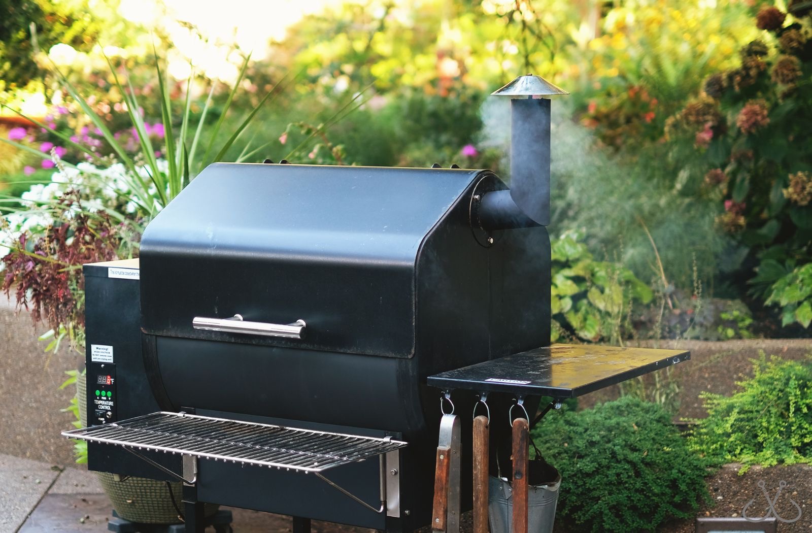 a black smoker grill in a backyard