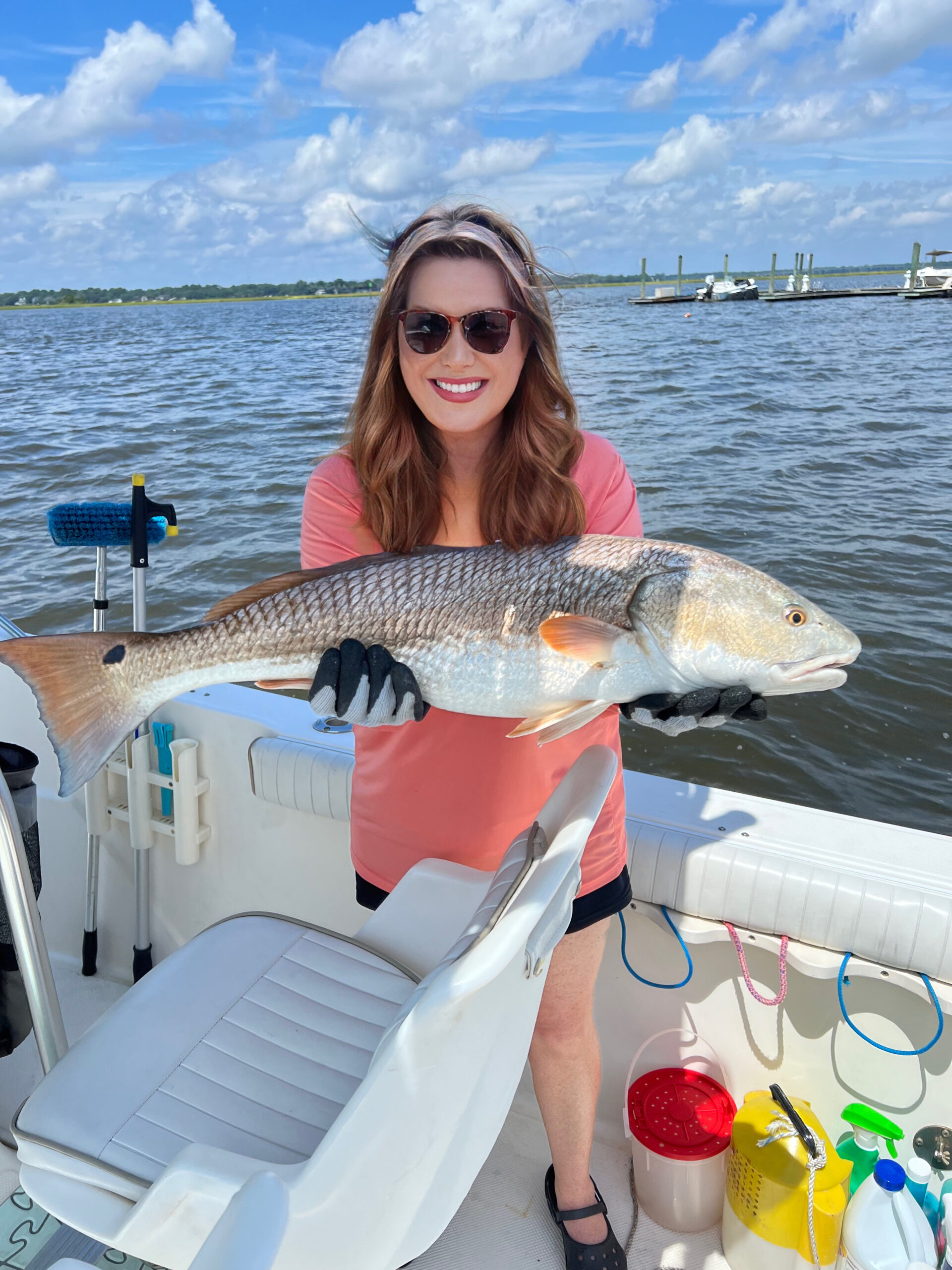 brunette female holding a jumbo redfish on a boat in the South Carolina Ashley River