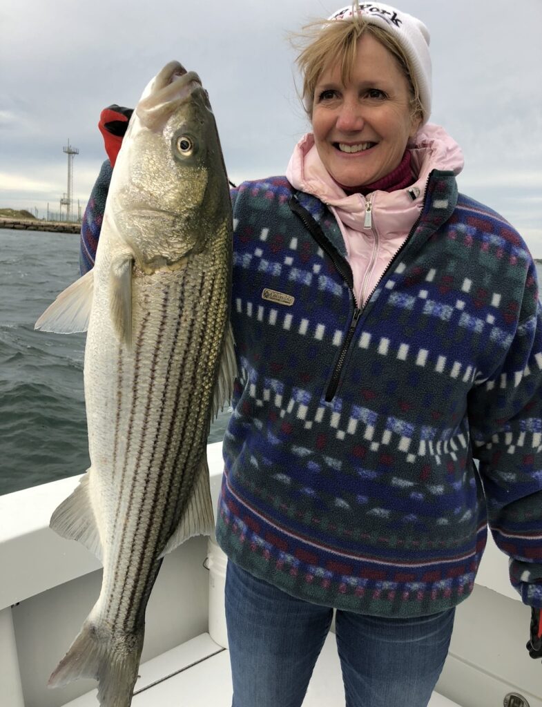 Angler holding a large fall-run striped bass caught from a charter boat off Shinnecock, Long Island
