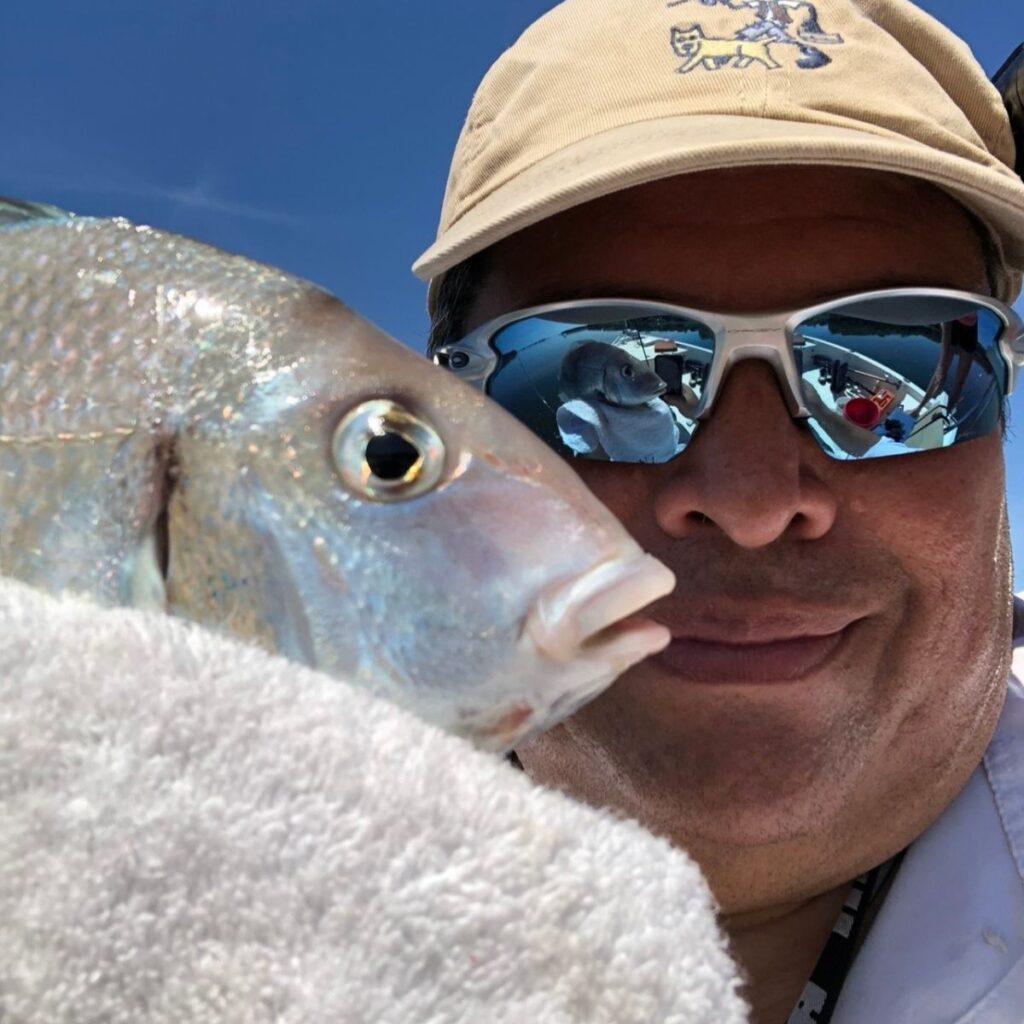 Captain Hank holding a porgy caught while fishing Long Island waters in the fall.