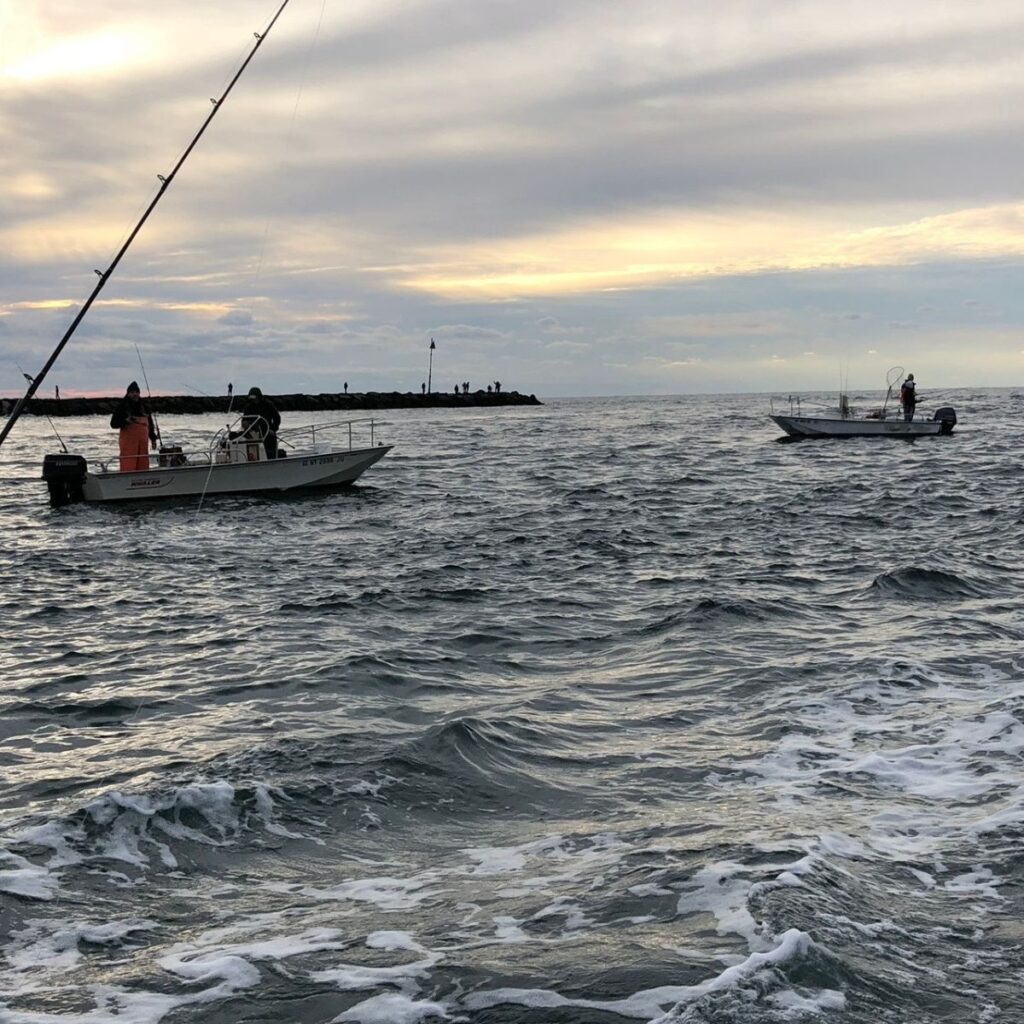 View of wavy water in Shinnecock Inlet with fishing boats in the background on Long Island's South Shore.
